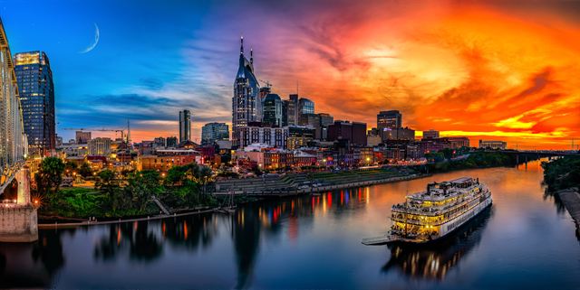 Nashville skyline at sunset over the Cumberland River, with the General Jackson riverboat
