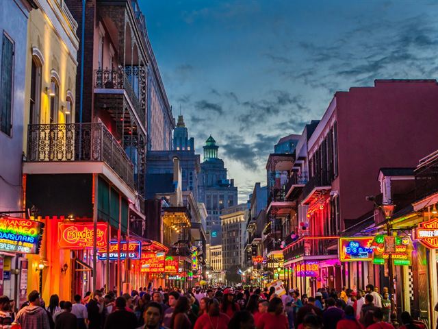 Bourbon Street in the French Quarter crowded and lit with neon at night