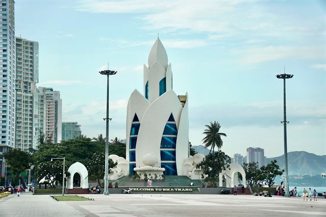 White lotus-shaped Tram Huong Tower on the Nha Trang seafront with hotel towers behind