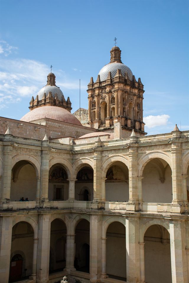 Arched cloister of the former Santo Domingo convent with the church's domes and bell towers in Oaxaca