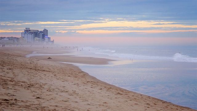 Misty morning on the beach in Ocean City, Maryland with gentle waves and high-rises in the distance
