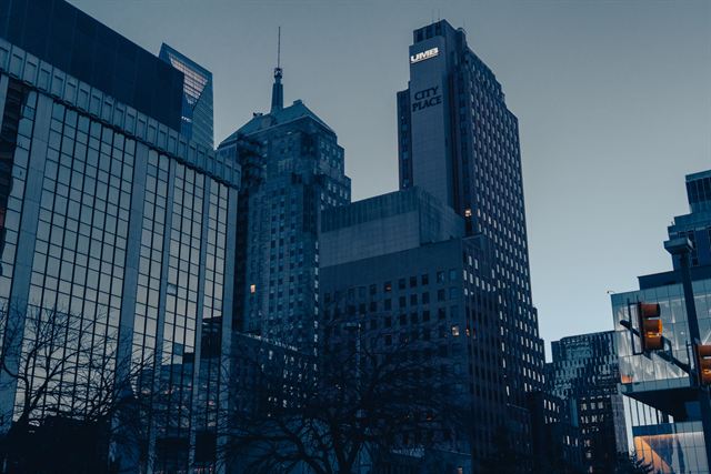 Low-angle view of downtown Oklahoma City skyscrapers against a deep blue dusk sky