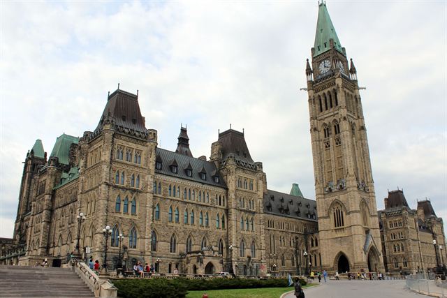 Centre Block and the Peace Tower clock tower of Canada's Parliament in Ottawa under a pale sky