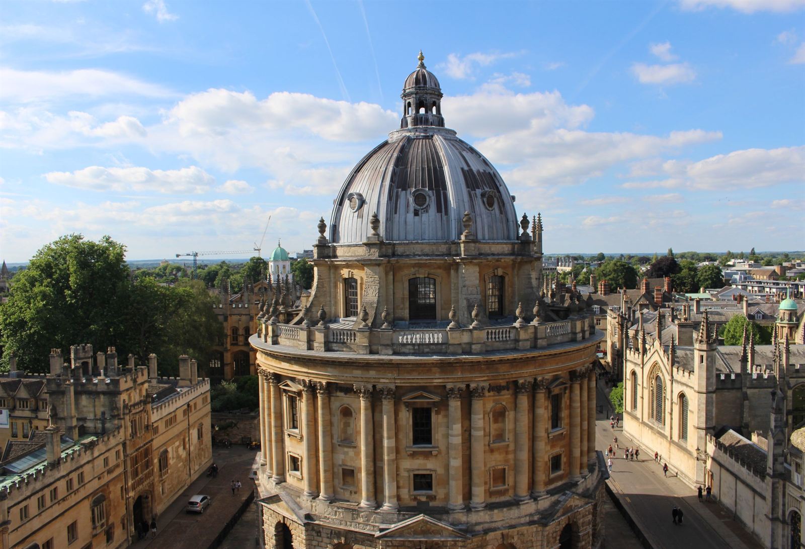 Radcliffe Camera's domed rotunda among Oxford college buildings seen from above on a sunny day