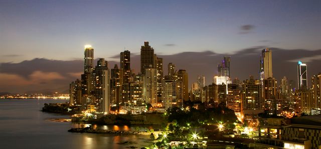 Panama City's high-rise skyline lit up at night across the water