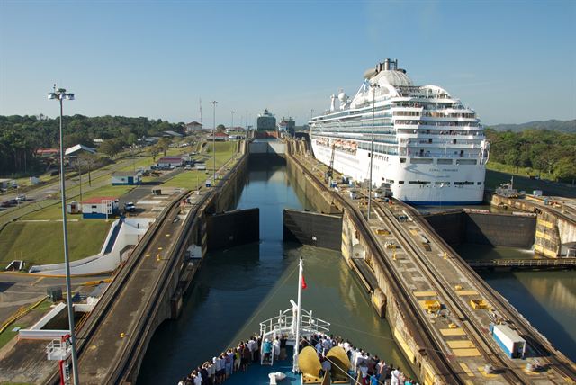 Cruise ship rising in a Panama Canal lock chamber, seen from the bow of another ship