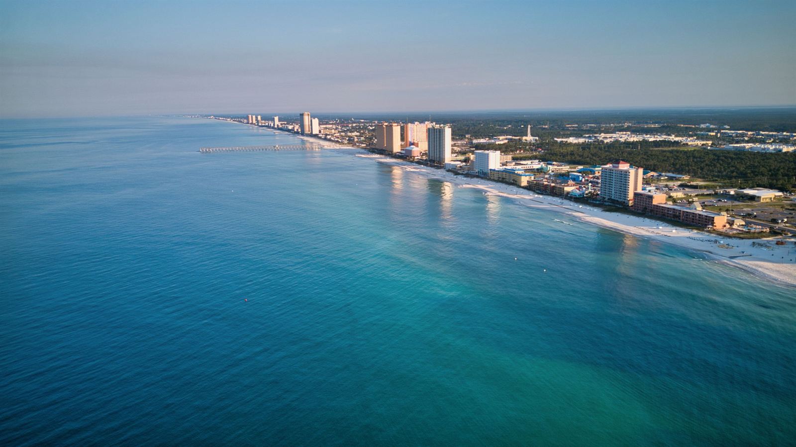 Aerial view of the Panama City Beach coastline with turquoise Gulf water and a line of beachfront high-rises