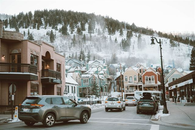 Historic Main Street in Park City, Utah in winter with colorful buildings and snowy ski slopes behind