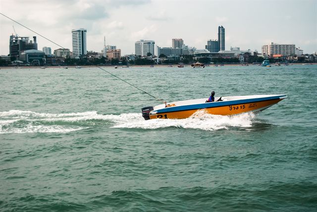 Speedboat racing across Pattaya Bay with the beachfront skyline on the horizon