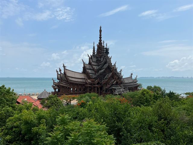 Sanctuary of Truth, a carved wooden temple with tall spires on the seafront at Pattaya