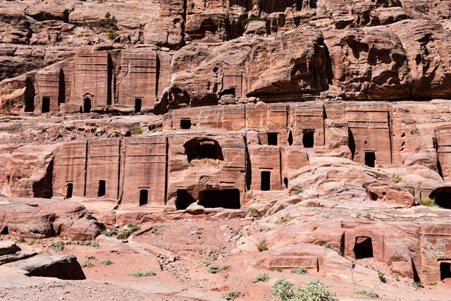 Rows of rock-cut Nabataean tombs in the red sandstone cliffs of Petra, Jordan