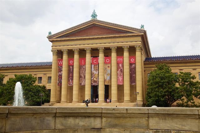 Columned facade of the Philadelphia Museum of Art with a fountain in front on a sunny day