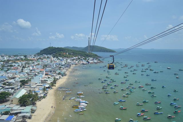 Hon Thom cable car gondola above fishing boats and the sandy shore of southern Phu Quoc
