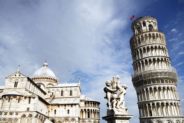 Leaning Tower of Pisa beside the cathedral dome and a baroque statue