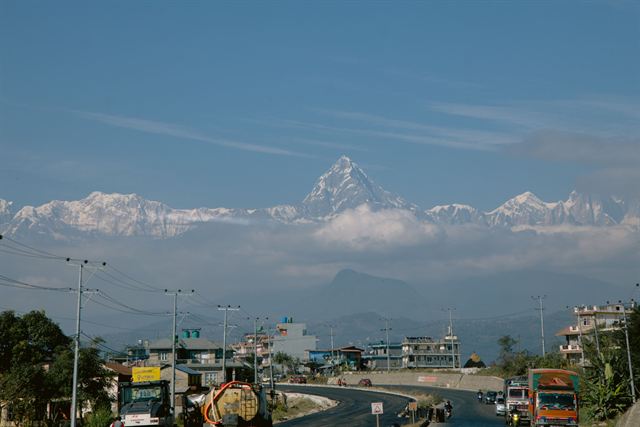 Snowy Machapuchare (Fishtail) peak and Annapurna range rising above a Pokhara street