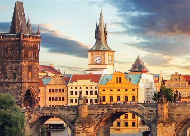 Charles Bridge in Prague with its Gothic bridge tower and Old Town spires at sunset