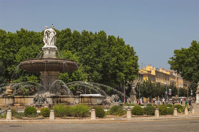 Fontaine de la Rotonde fountain at the heart of Aix-en-Provence with plane trees and townhouses
