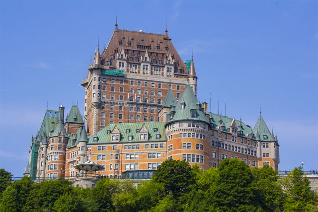 Fairmont Le Chateau Frontenac's green copper roofs and turrets rising above trees in Quebec City