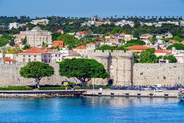 Medieval walls and gate of Rhodes Old Town above the harbor with the town rising behind