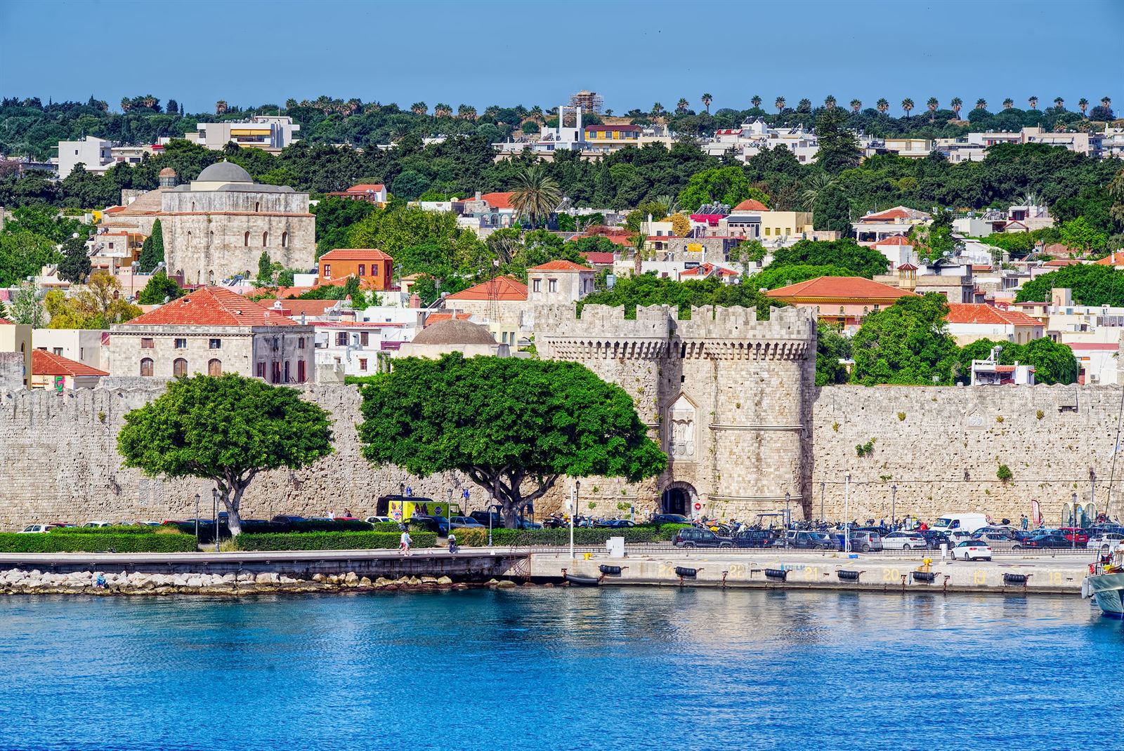 Medieval walls and gate of Rhodes Old Town above the harbor with the town rising behind