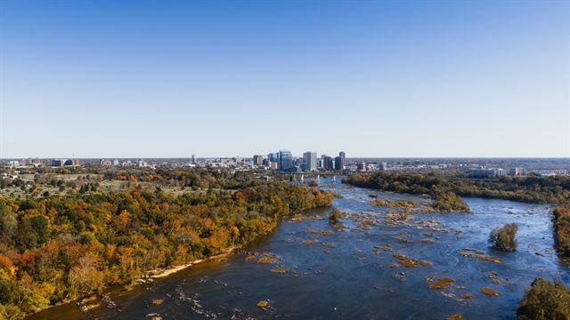 Aerial view of the James River rapids and autumn woodland leading to the Richmond, Virginia skyline