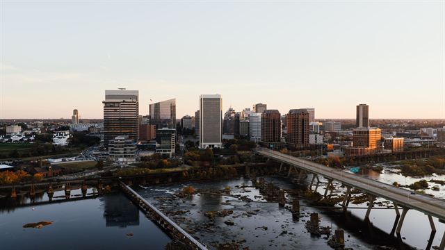 Richmond, Virginia skyline at sunset seen above bridges and the James River