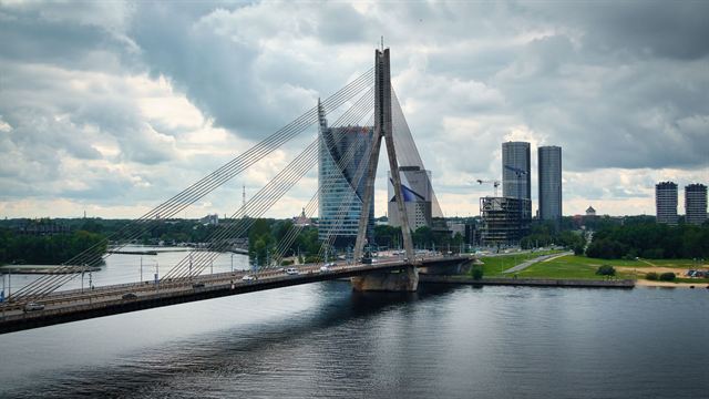 Vansu cable-stayed bridge over the Daugava River with Riga's modern high-rises under cloudy sky