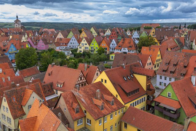 Aerial view of Rothenburg ob der Tauber's red roofs and colorful medieval houses toward green countryside