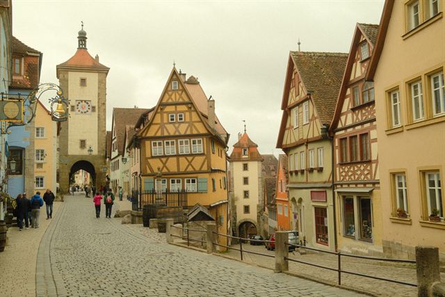 The Ploenlein in Rothenburg ob der Tauber, a yellow half-timbered house between two gate towers