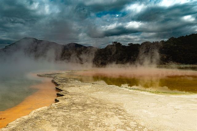 Champagne Pool at Wai-O-Tapu near Rotorua with orange mineral rim and rising steam