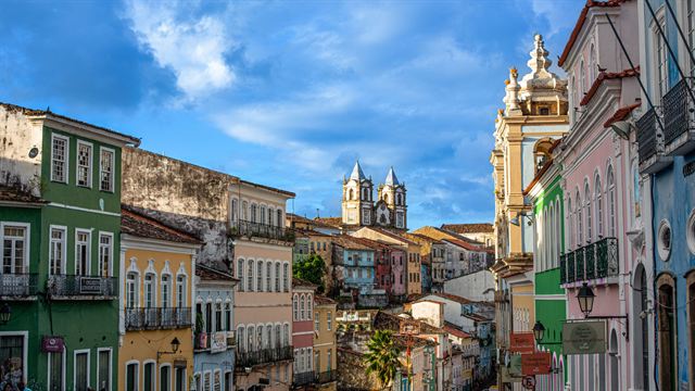 Pastel colonial facades and church towers lining a sloping street in Salvador's historic Pelourinho