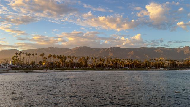 Santa Barbara waterfront palms beneath the Santa Ynez Mountains and golden sunset clouds