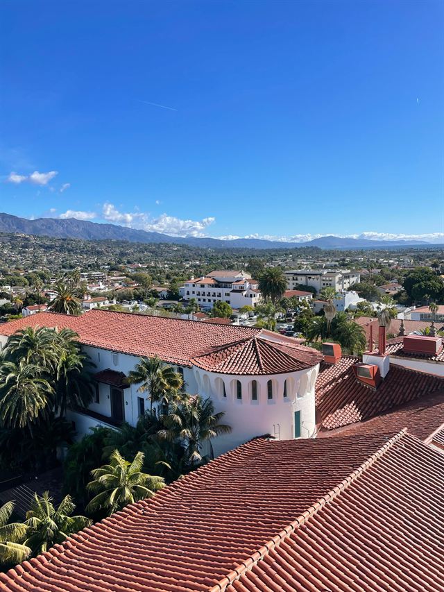 Red-tiled roofs of downtown Santa Barbara and the county courthouse with hills and ocean beyond
