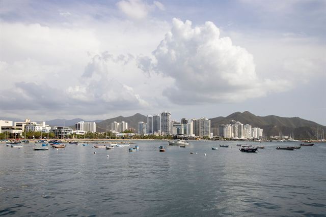 Santa Marta bay with moored boats, waterfront high-rises and the Sierra Nevada foothills behind