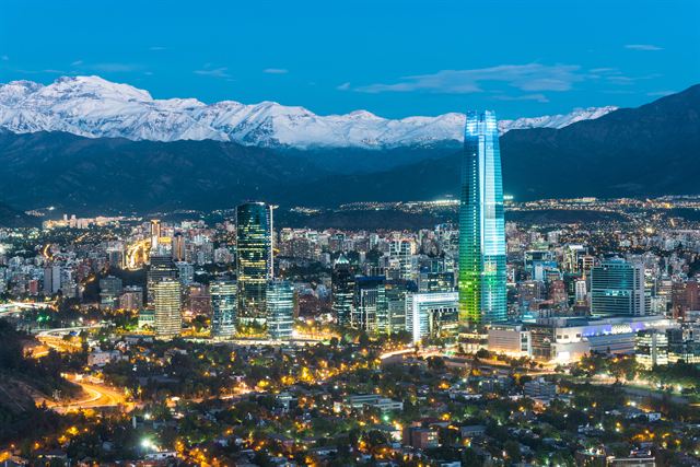 Santiago skyline at dusk with the lit Gran Torre Costanera and snow-capped Andes behind