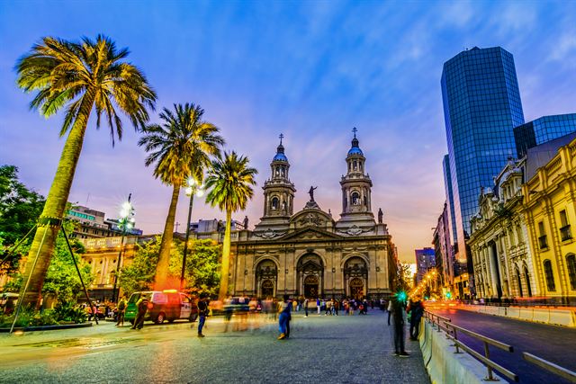 Plaza de Armas with the Metropolitan Cathedral, palms and modern towers at twilight, Santiago