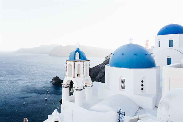 Blue-domed white churches of Oia, Santorini, overlooking the caldera sea
