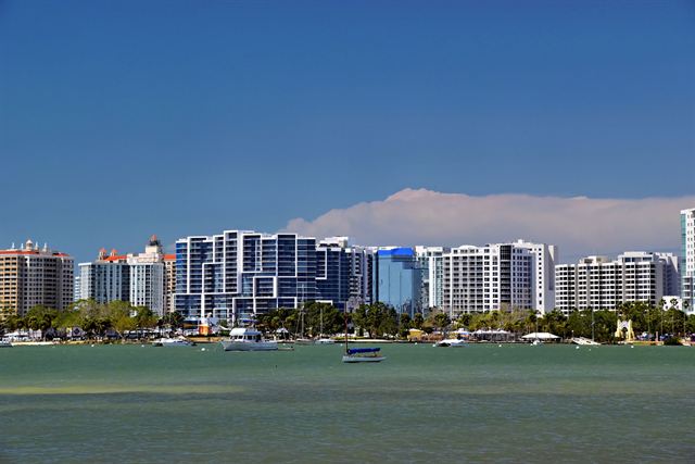 Sarasota's waterfront skyline of white condo towers across the bay under a blue sky