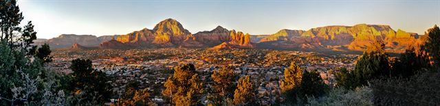 Panorama of Sedona’s red rock buttes and town at golden hour, Arizona