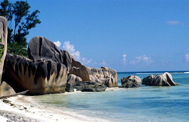 Giant weathered granite boulders on a white-sand beach at La Digue in the Seychelles