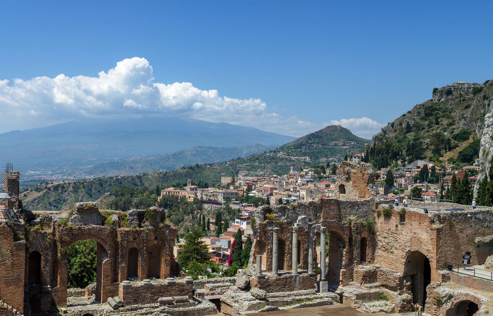 Taormina, Sicily: ruins of the ancient Greek Theatre with the town, coast and Mount Etna behind