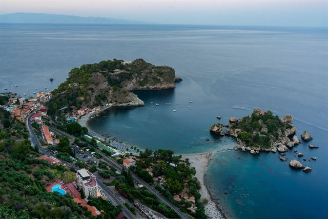 Taormina, Sicily: aerial view of Isola Bella islet and its bay below the wooded Taormina coastline