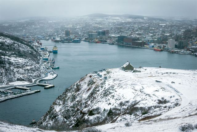 Snowy view of St. John's harbour and city from Signal Hill with docks along the water