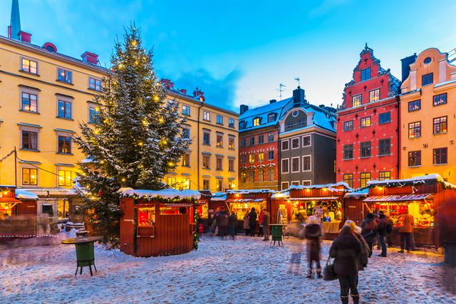 Christmas market in Stortorget square, Stockholm, with colorful gabled houses and snow