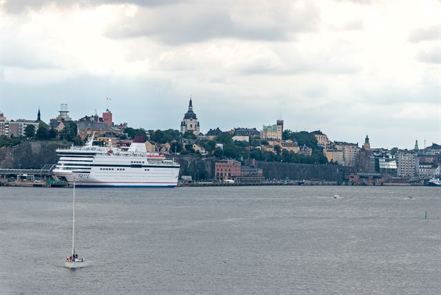 Stockholm Sodermalm skyline with church dome and a white ferry on the harbor