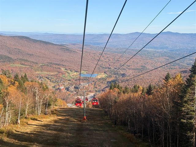 View from the Stowe gondola over autumn-colored Vermont forest, ski trails and distant valleys