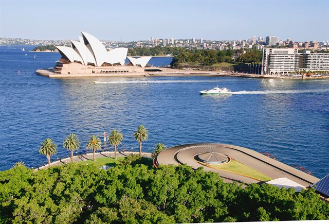 Sydney Opera House on Bennelong Point seen from above with the harbour and ferry