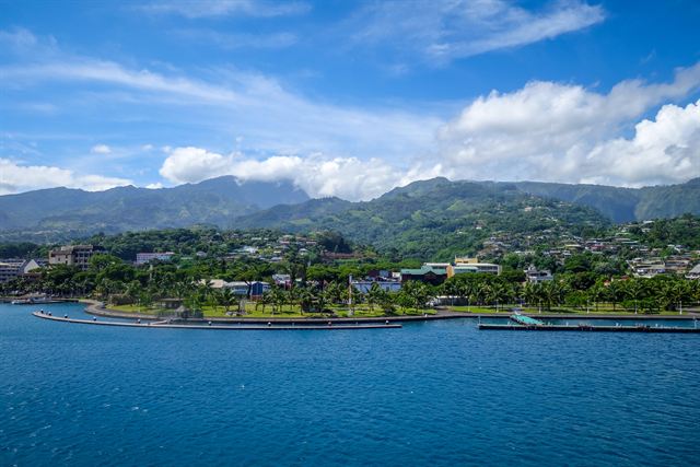 Papeete waterfront and harbor below the green volcanic mountains of Tahiti, French Polynesia