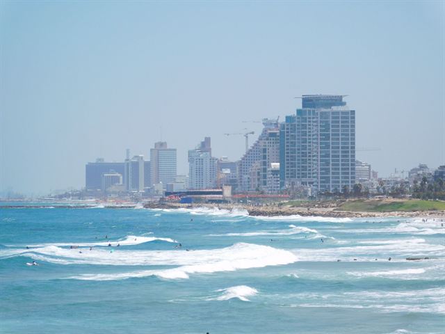 Tel Aviv beachfront with white surf and hotel towers along the Mediterranean shore