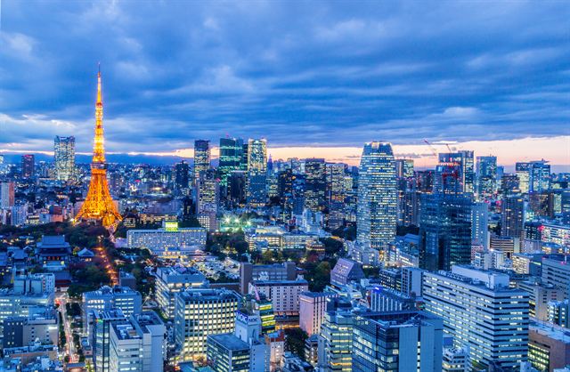 Tokyo Tower lit up at dusk above a dense city skyline
